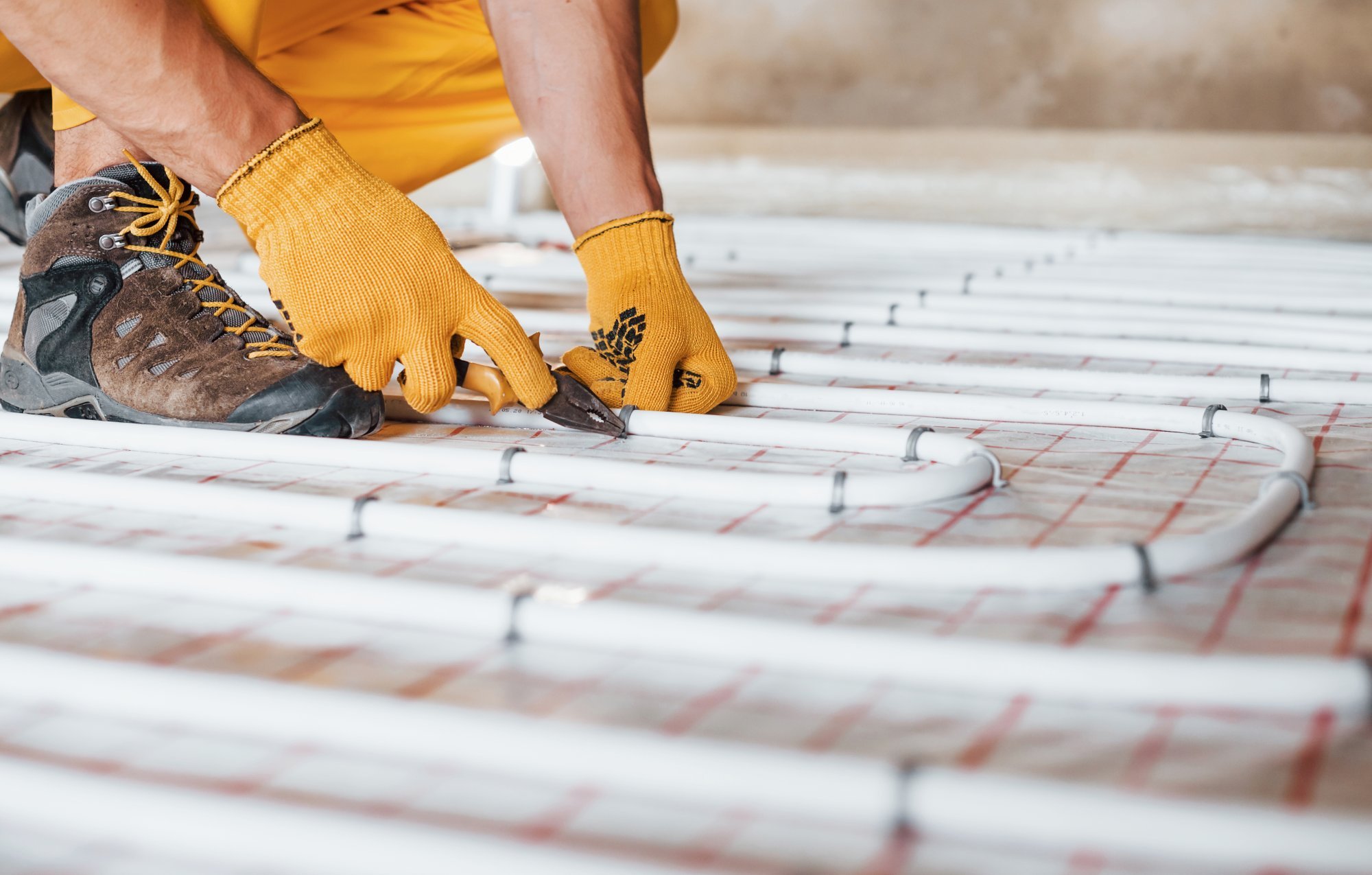 close-up-view-worker-yellow-colored-uniform-installing-underfloor-heating-system.jpg