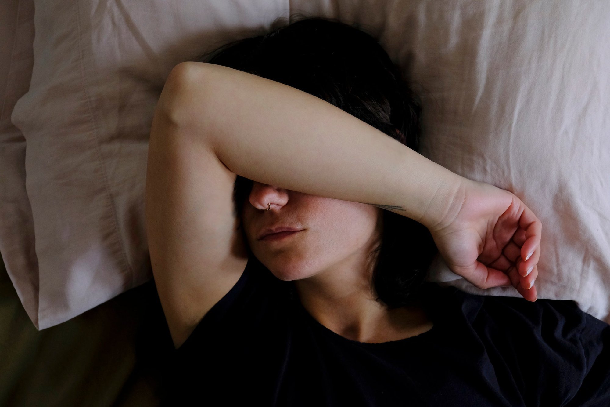 person-lays-down-with-one-arm-up-to-cover-their-eyes.jpg
