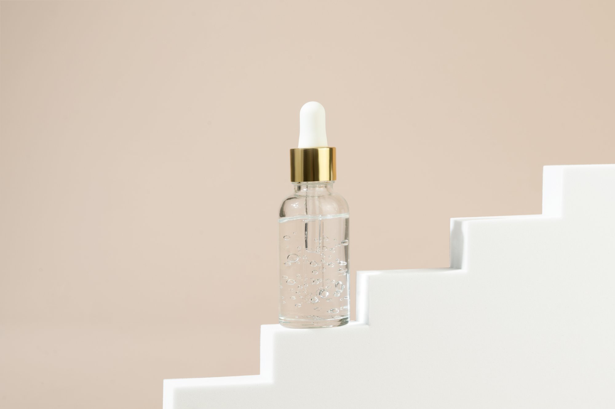 dropper-bottle-with-transparent-natural-gel-oil-serum-face-standing-white-stairs.jpg