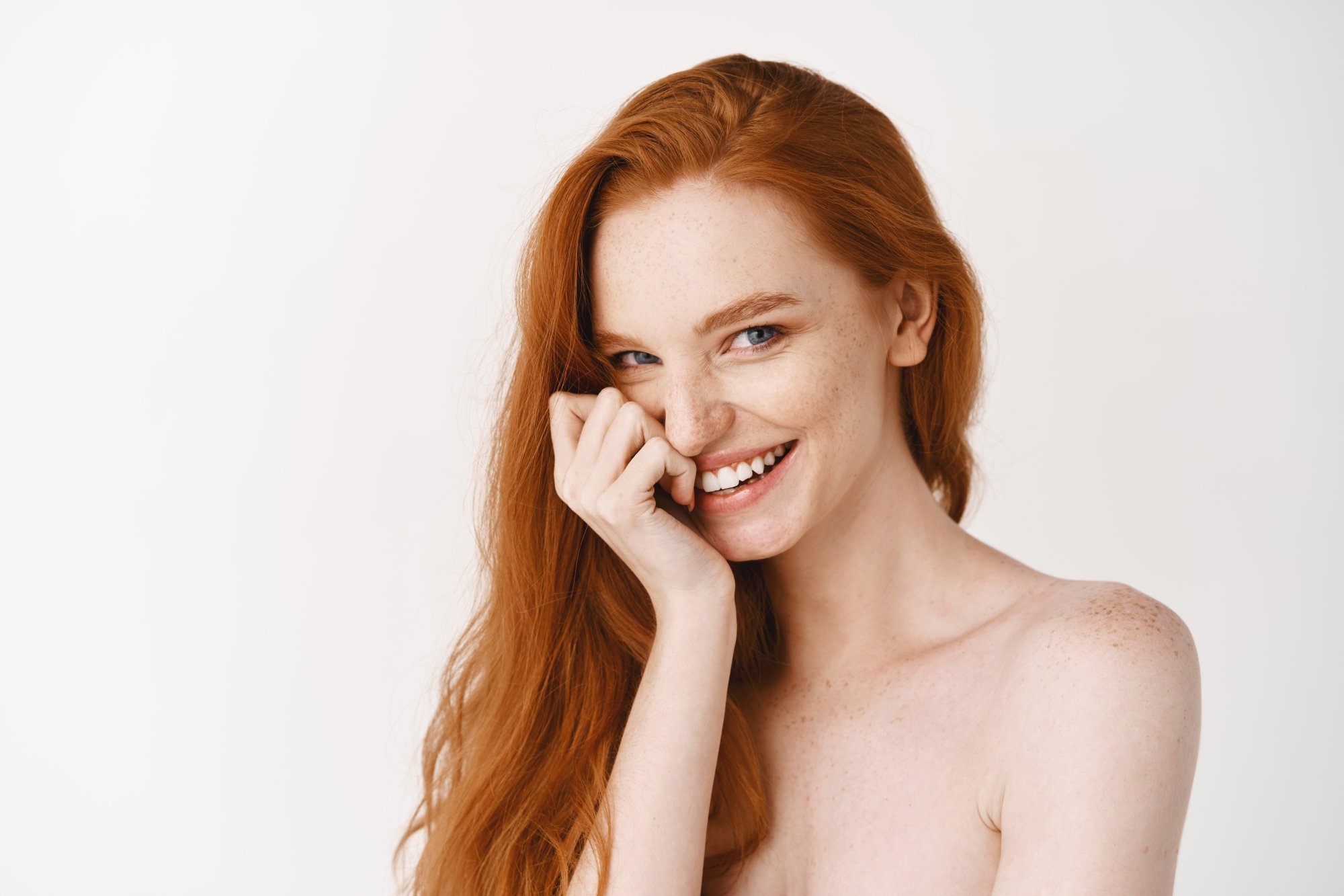 close-up-happy-redhead-woman-with-pale-perfect-skin-laughing-showing-white-teeth-standing-naked-studio-wall.jpg